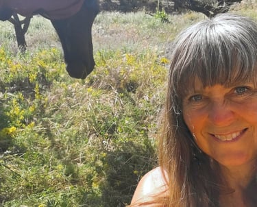 Portret van een vrouw in de natuur met een paard in de achtergrond