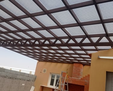 برجولة حديد بتغطية عازلة في الرياض توفر ظلًا وحماية للمساحات الخارجية.