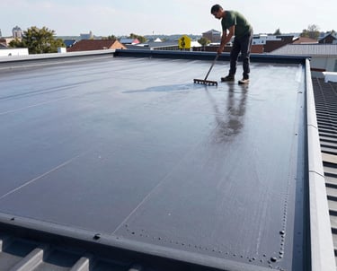 Close-up of a worker applying primer to a roof before silicone coating on a sunny day.