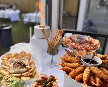 Servicio de catering gourmet con camarones fritos, hummus y aperitivos de cóctel en un evento 