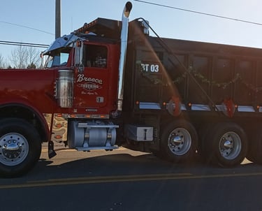 Dump Truck riding down the road, trucking services