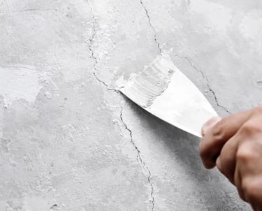 A professional is fixing cracks on the wall prior interior or extrior paint application