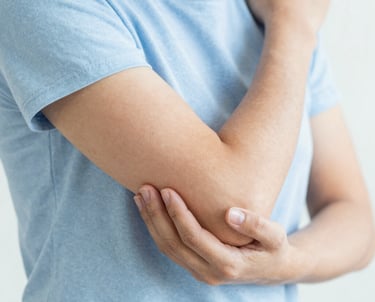 Orthopedic surgeon reviewing knee X-rays with a patient in a bright consultation room.