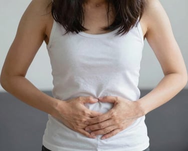 A woman smiling gently while holding a cup of herbal tea in a cozy kitchen.