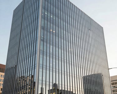 A landscape photograph of a modern, glass-walled office building in North America during a bright morning. The atmosphere is professional, efficient, and innovative.