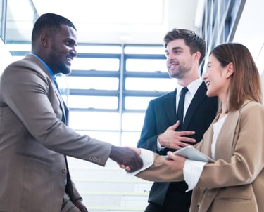 Business professionals shaking hands and referring one another