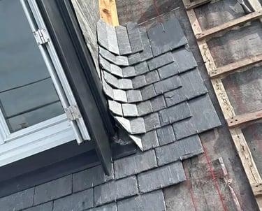 Détail d'une pose artisanale de couverture en ardoise et finitions d'étanchéité en zinguerie dans le Finistère