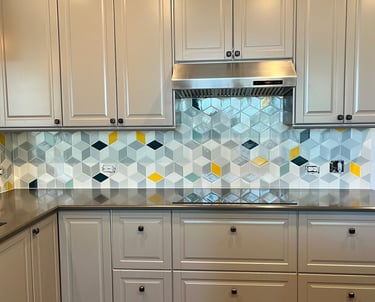 Modern kitchen with grey cabinets and a geometric hexagon tile backsplash featuring yellow accents.