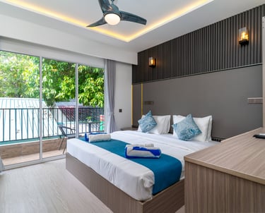 Modern hotel room with king bed, balcony view, and contemporary interior design.
