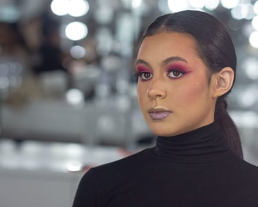 Una modelo que luce una atrevida sombra de ojos rosa y un lápiz labial brillante para lograr un look