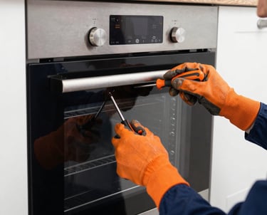 Technician fixing a refrigerator with tools in a bright, clean kitchen.