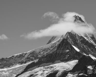 a mountain peak with a cloud in the background
