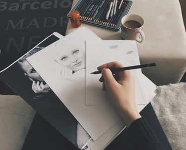 A person holding pen on top of the drawing paper