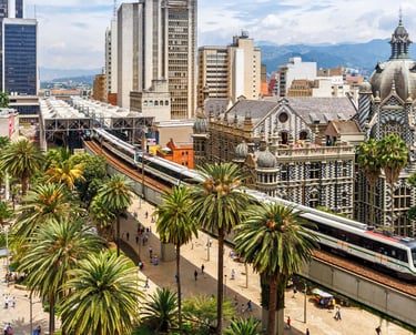 Elevated Metro train passing the Palacio de la Cultura and palm trees in downtown Medellin, Colombia.