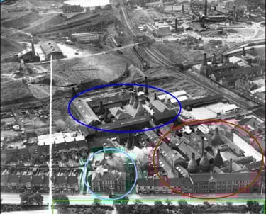 Historic aerial view of pottery factories with bottle kilns in Stoke-on-Trent industrial landscape.