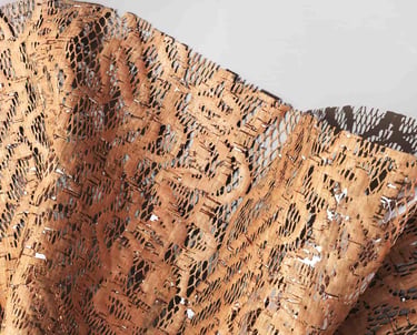 Eco-friendly sustainable laser-cut natural cork fabric with a mesh pattern for fashion design.