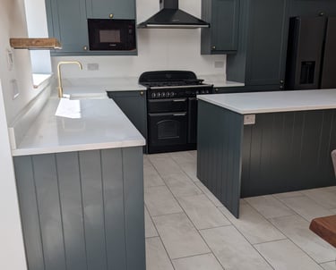 white counter top kitchen with a dark green/light grey wood cupboards