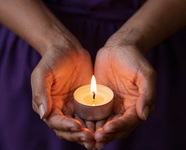 A close-up photograph of a South American woman's hands holding a sacred golden amulet, lit by warm flickering candlelight. The background is a rich dark purple fabric, evoking trust and mystery.