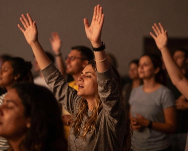 A small group of diverse men and women studying the Bible together in a cozy room filled with natural light.