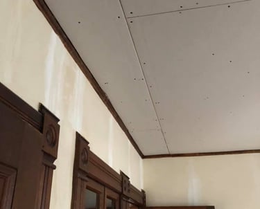 new drywall hung on ceiling of home with wood trim