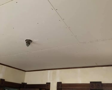 new drywall hung on ceiling of home with wood trim