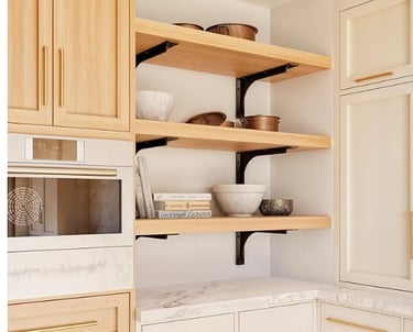 Light wood floating shelves with black metal brackets in a modern farmhouse kitchen.