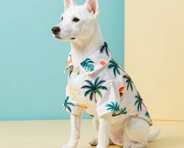 Un perrito blanco con una camisa hawaiana estampada con palmeras tropicales sobre un fondo pastel.