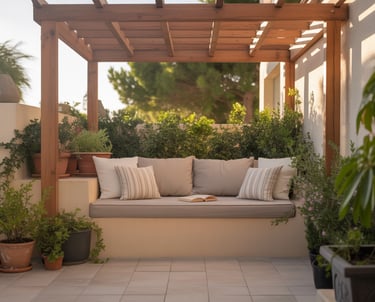A compact patio reading nook with a wooden pergola roof, built-in bench with neutral cushions, potte