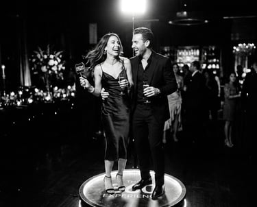 A happy couple laughing on a 360 photo booth at a luxury black-tie event or wedding reception.