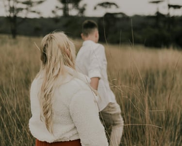 a man and woman standing in tall grass