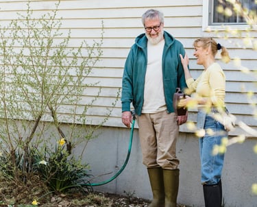 an old married couple standing in front of a house
