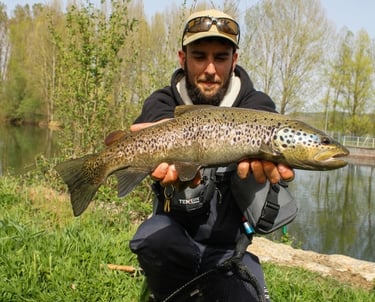 Pescador con una gran trucha en el río Porma