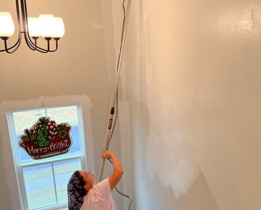 Team member painting stairway wall.