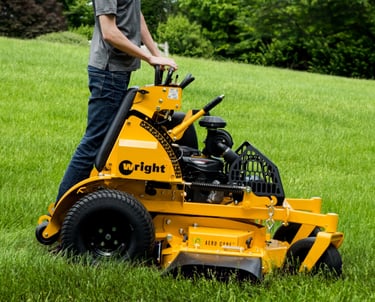 Wright Stander X mower with a team member mowing grass.