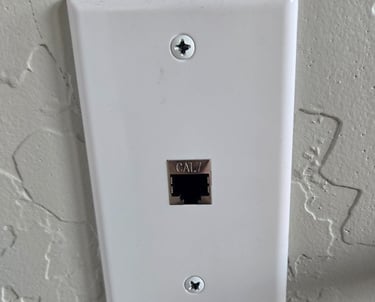 White Cat 7 ethernet wall plate with a single RJ45 network jack installed on a textured wall.