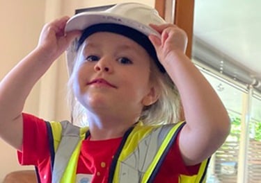 A young future construction boss in a safety helmet