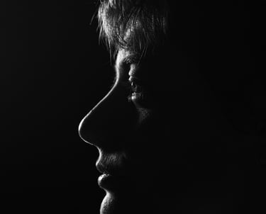 Dramatic black and white profile silhouette of a person's face using low-key lighting.
