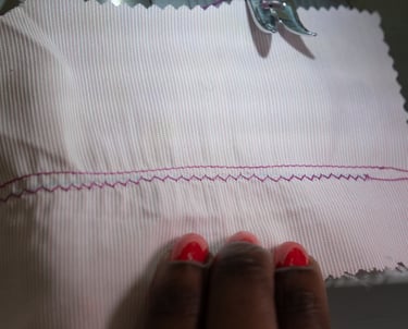 Straight stitch parallel to zig zag stitches shown on pink fabric
