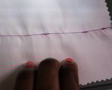 Backstitching shown on pink fabric