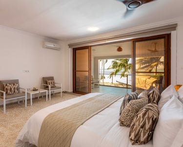 a bedroom with a bed and a couch and a ocean view in Zanzibar