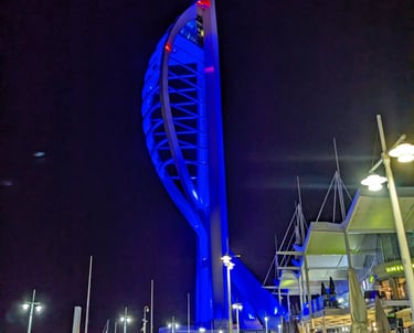 Spinnaker Tower lit up in blue against a dark night sky