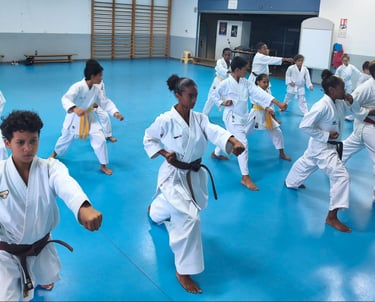 a group of young people in karate gear practicing karate moves