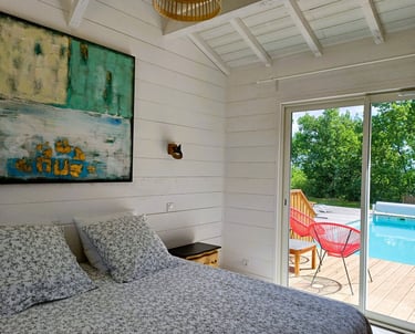 a bedroom with a large bed and a pool in the background Maison Les Terrasses Master suite