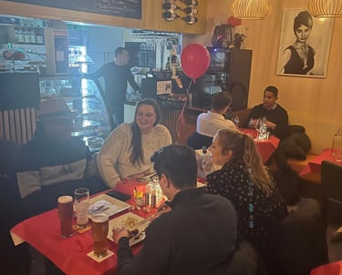 a group of people sitting at a table with balloons