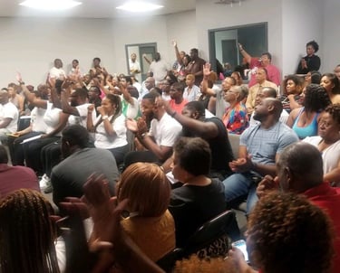 Group of people in an office raising their hands