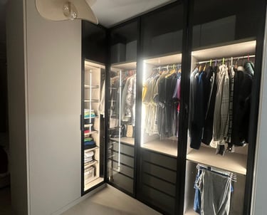 Vestidor moderno con iluminación interior y puertas de vidrio.
