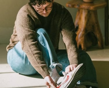 Dakota puting on his shoe in a casual setting