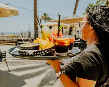 Waitress serving drinks and nachos on the terrace at Santa Lola Badalona