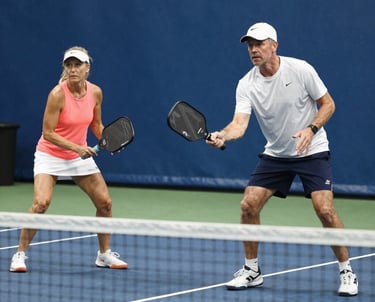 A friendly agent sitting with a senior couple, reviewing Medicare Advantage plan options in a bright office.