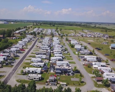 Aerial view of a luxury RV resort with rows of travel trailers and motorhomes parked in campsites.